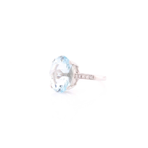 312 - A single stone aquamarine ring, the oval cut aquamarine in four claw mount above five stone eight-cu... 