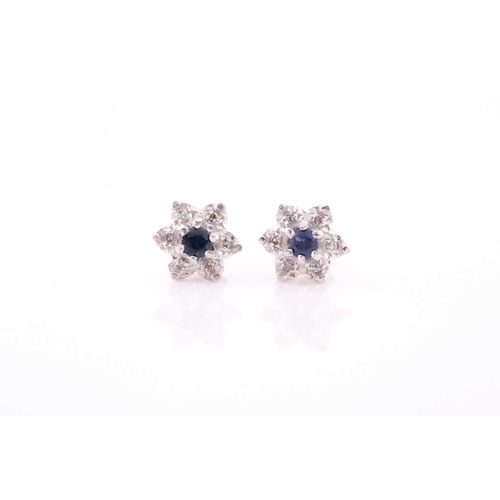 314 - A pair of diamond and sapphire floral cluster earrings, set in white metal mounts, the yellow metal ... 