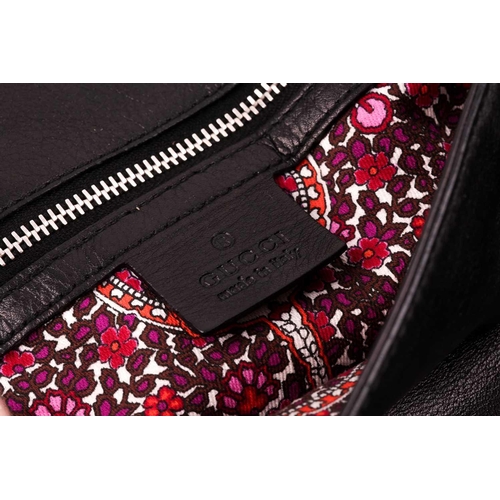 327 - Gucci. A black leather handbag, with chrome fittings and wide shoulder strap, paisley material lied ... 