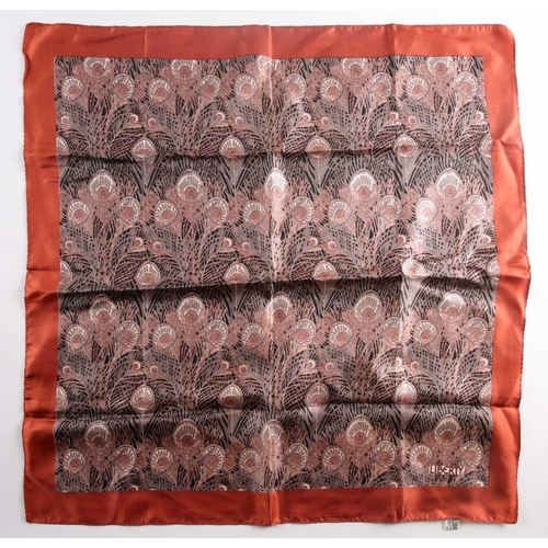 332 - A Liberty silk square scarf with peacock feathers on a black ground with a rust border, together wit... 