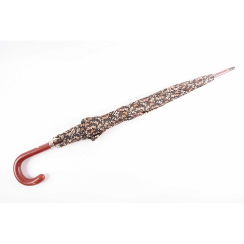 340 - A Ferragamo silk umbrella printed with horses on a black ground, with leather handle.