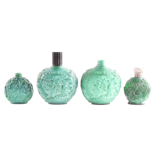 342 - A collection of four carved and moulded green glass scent bottles; carved with scenes from rural lif... 