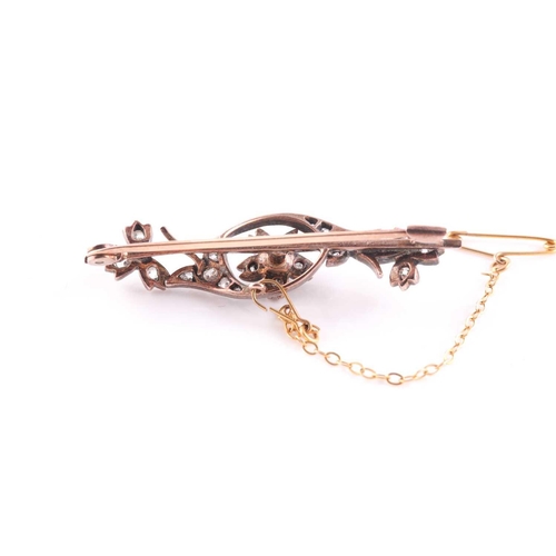 61 - A late 19th / early 20th century yellow metal floral bar brooch, inset with old-cut diamonds and cen... 