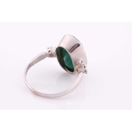 62 - An 18ct white gold, diamond, and emerald ring, set with a low grade mixed oval-cut emerald flanked w... 