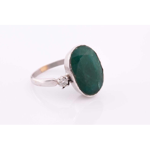 62 - An 18ct white gold, diamond, and emerald ring, set with a low grade mixed oval-cut emerald flanked w... 