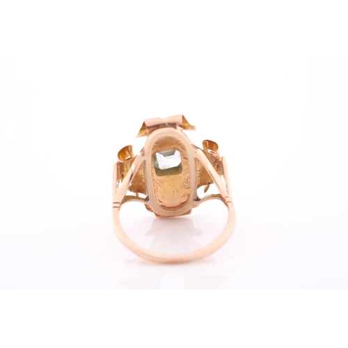 68 - A late 19th century yellow metal and aquamarine ring, the ornate rectangular mount with scrolled dec... 