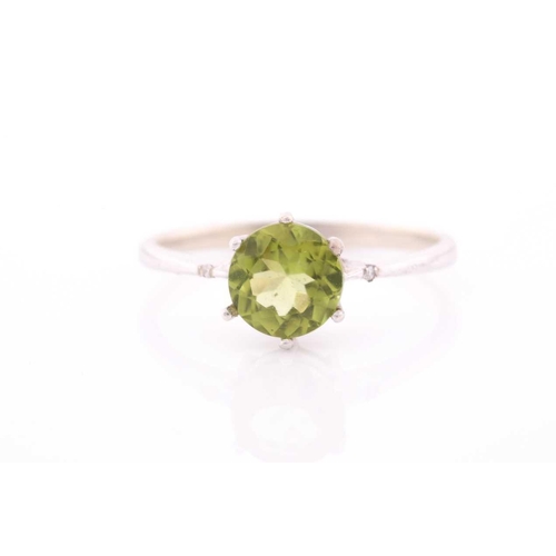 69 - A peridot and diamond ring, centred with a mixed round-cut peridot, approximately 7.6 mm diameter, e... 