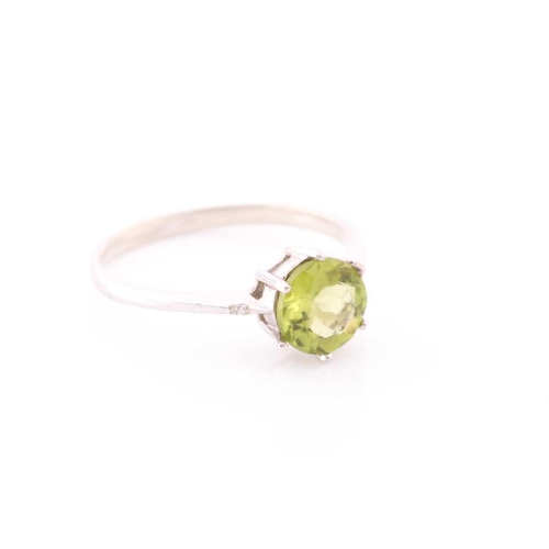 69 - A peridot and diamond ring, centred with a mixed round-cut peridot, approximately 7.6 mm diameter, e... 