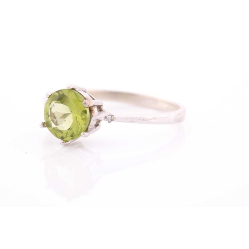 69 - A peridot and diamond ring, centred with a mixed round-cut peridot, approximately 7.6 mm diameter, e... 