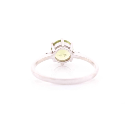69 - A peridot and diamond ring, centred with a mixed round-cut peridot, approximately 7.6 mm diameter, e... 