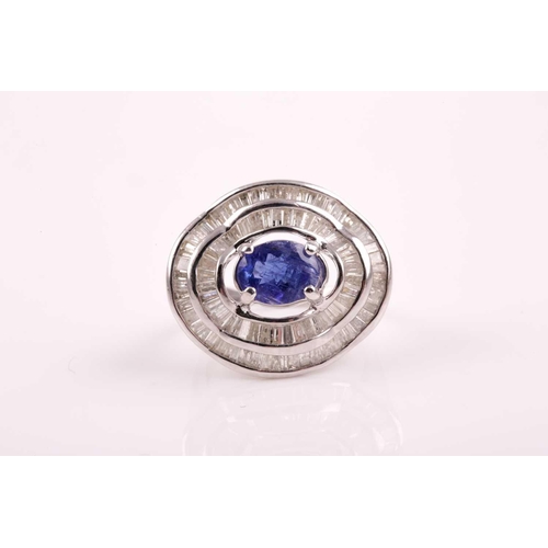 74 - A silver, diamond, and tanzanite ring, set east to west with a mixed oval-cut tanzanite of approxima... 