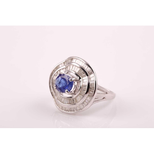 74 - A silver, diamond, and tanzanite ring, set east to west with a mixed oval-cut tanzanite of approxima... 