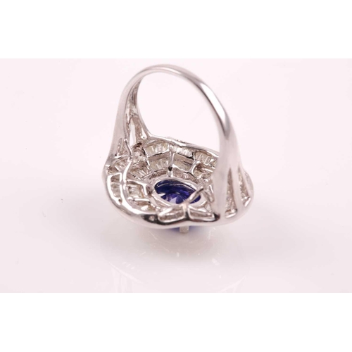 74 - A silver, diamond, and tanzanite ring, set east to west with a mixed oval-cut tanzanite of approxima... 