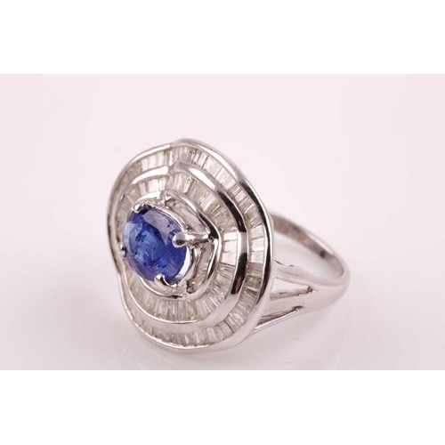 74 - A silver, diamond, and tanzanite ring, set east to west with a mixed oval-cut tanzanite of approxima... 