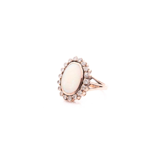 113 - A diamond and opal dress ring, set with an oval cabochon opal within a rubover setting, surrounded w... 