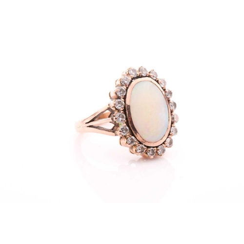 113 - A diamond and opal dress ring, set with an oval cabochon opal within a rubover setting, surrounded w... 