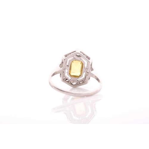 125 - A platinum, diamond, and sapphire dress ring, set with an emerald-cut yellow sapphire of approximate... 