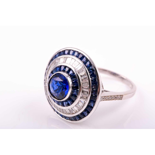 127 - A sapphire and diamond cluster ring; the central circular cut sapphire in rubover mount within conic... 