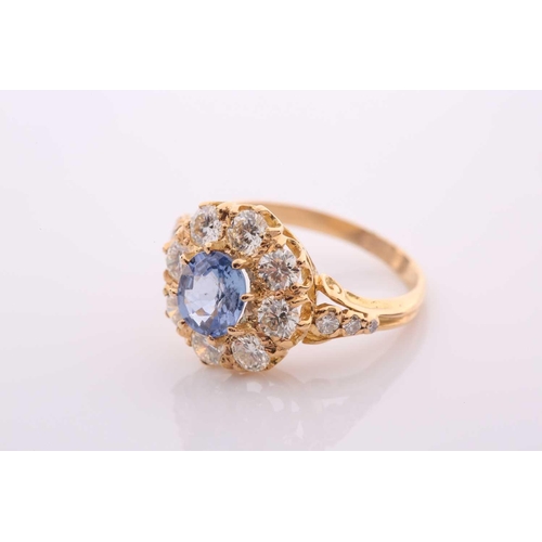152 - A modern sapphire and diamond oval cluster ring in Victorian style, centred with an oval native-cut ... 