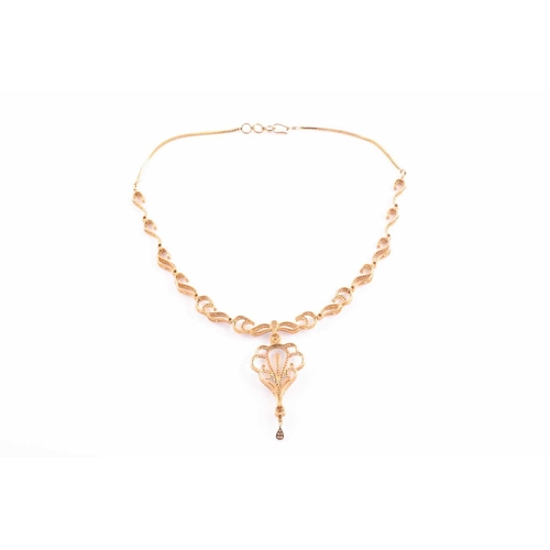 219 - An Indian diamond set necklace; the centre with a diamond set scrolling, openwork drop, from a circu... 