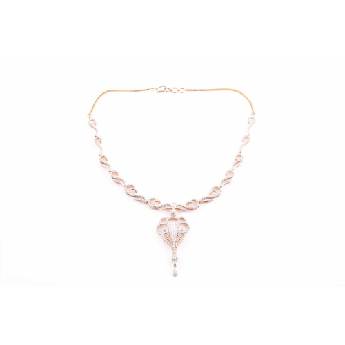 219 - An Indian diamond set necklace; the centre with a diamond set scrolling, openwork drop, from a circu... 