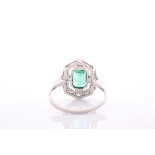 77 - A modern emerald and diamond pointed-rectangular cluster ring in Art Deco style, centred with an eme... 