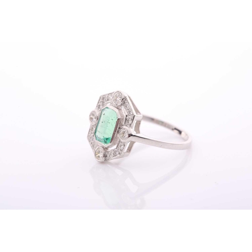 77 - A modern emerald and diamond pointed-rectangular cluster ring in Art Deco style, centred with an eme... 