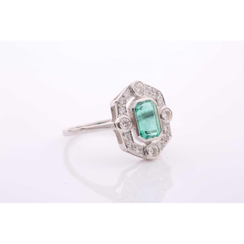 77 - A modern emerald and diamond pointed-rectangular cluster ring in Art Deco style, centred with an eme... 
