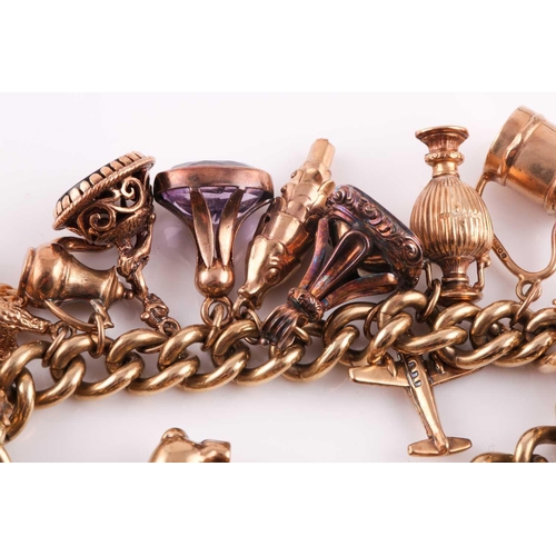 81 - A 9ct gold curb link ‘charm bracelet on a padlock clasp, London 1975, and hung with 16 various charm... 