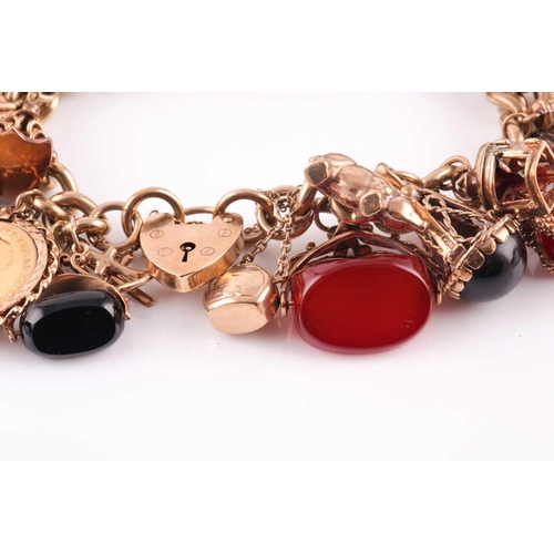 81 - A 9ct gold curb link ‘charm bracelet on a padlock clasp, London 1975, and hung with 16 various charm... 