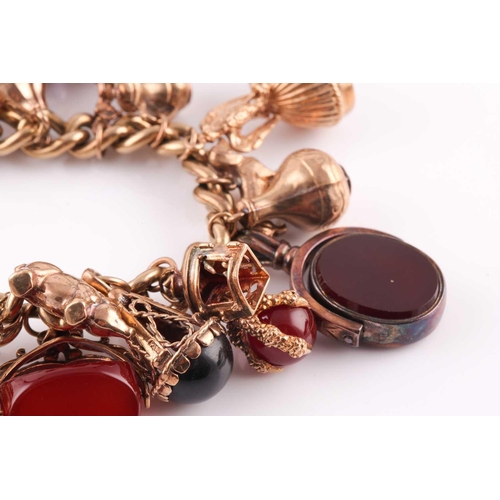 81 - A 9ct gold curb link ‘charm bracelet on a padlock clasp, London 1975, and hung with 16 various charm... 