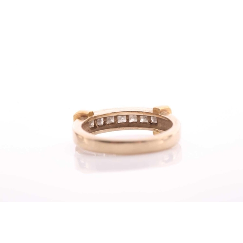 82 - A seven stone half hoop diamond ring; the princess cut diamonds channel set within a bi coloured 18 ... 