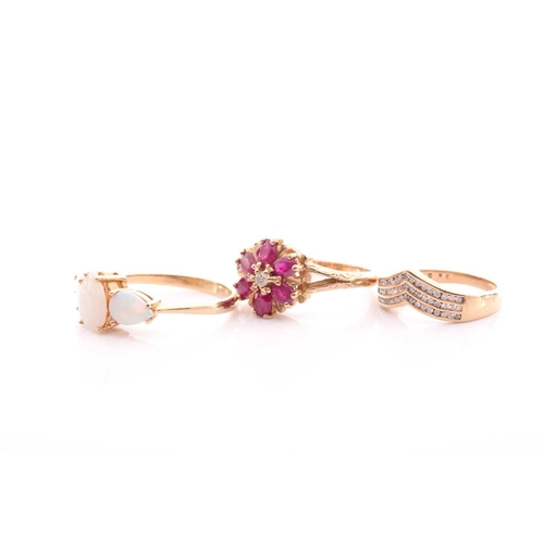 84 - A ruby and diamond cluster ring, in 9 carat gold mount with carved shoulders, a three stone opal hal... 