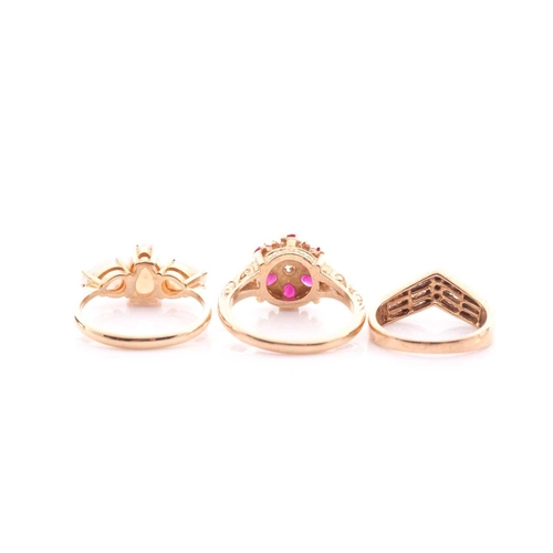 84 - A ruby and diamond cluster ring, in 9 carat gold mount with carved shoulders, a three stone opal hal... 