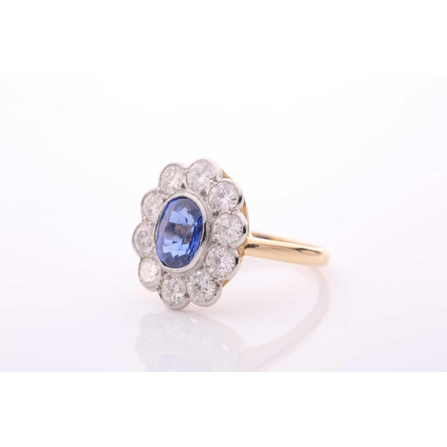 95 - A modern sapphire and diamond oval cluster ring, centred with an oval mixed-cut sapphire approximate... 