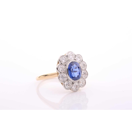 95 - A modern sapphire and diamond oval cluster ring, centred with an oval mixed-cut sapphire approximate... 
