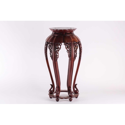 115 - A Chinese vase stand, early 20th century, the channel carved and shaped legs with archaic chilong st... 