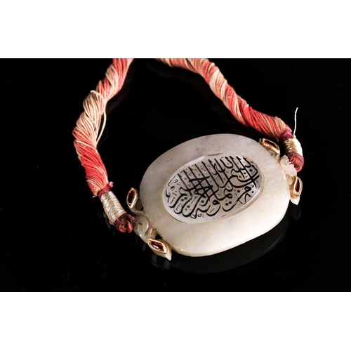 119 - An Indian white Jade necklace with oval central panel with yellow metal set red stones detail, the p... 