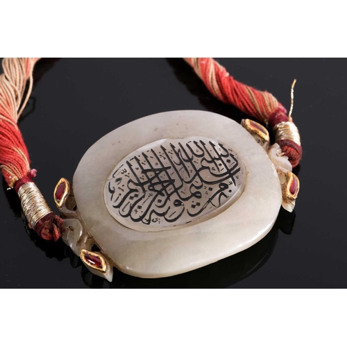 119 - An Indian white Jade necklace with oval central panel with yellow metal set red stones detail, the p... 