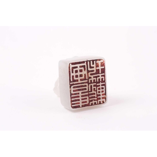 134 - A Chinese white jade seal, the seal of rectangular form surmounted by a recumbent lion dog, signed, ... 