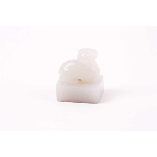 134 - A Chinese white jade seal, the seal of rectangular form surmounted by a recumbent lion dog, signed, ... 