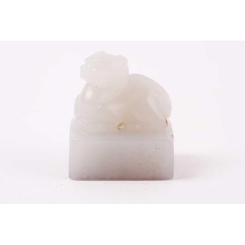 134 - A Chinese white jade seal, the seal of rectangular form surmounted by a recumbent lion dog, signed, ... 