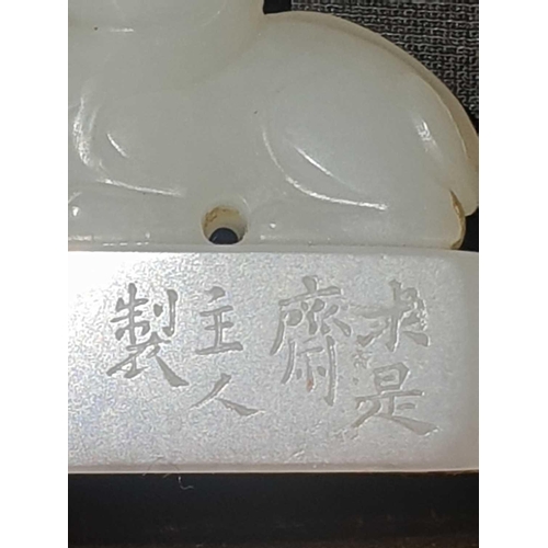 134 - A Chinese white jade seal, the seal of rectangular form surmounted by a recumbent lion dog, signed, ... 