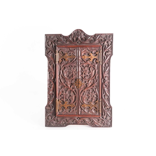 169 - An Indian carved padouk picture frame, late 19th century, with gothic brass hinges, and later oak ea... 