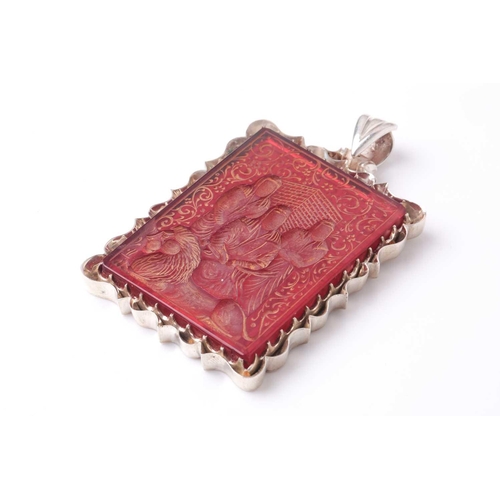 180 - A Persian white metal mounted rectangular red hardstone rectangular cartouch pendant, intaglio cut w... 