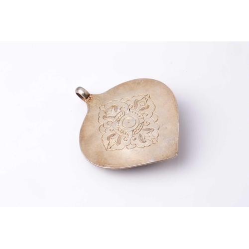 188 - A Tibetan white metal blind filigree worked leaf-shaped pendant mounted with a figure of Green Tara ... 