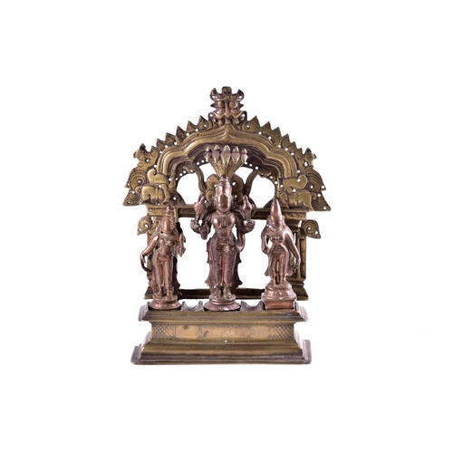 217 - An Indian brass shrine with Vishnu flanked by consorts Sridevi & Bhudevi, beneath a Shesha canopy, t... 