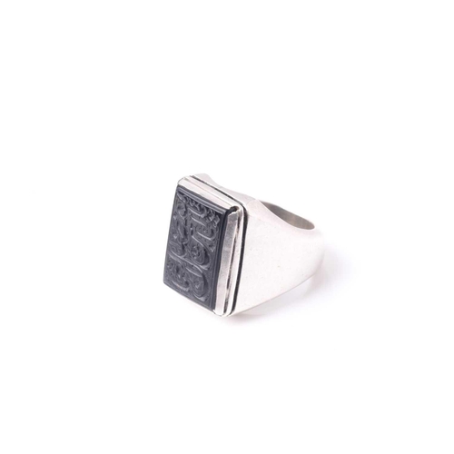 223 - An Eastern white metal and black onyx gentleman's ring, the rectangular stone with intaglio cut Isla... 