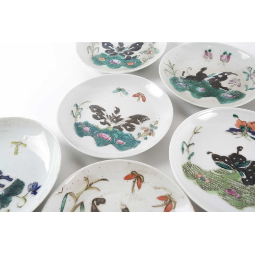 244 - A quantity of Chinese saucers, early 20th century, loosely painted in enamels with butterflies above... 