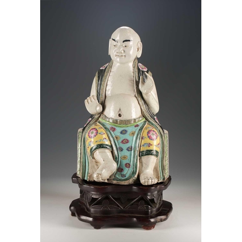 256 - A Chinese porcelain figure of a seated Luohan, Qing, 18th/19th century, his facial features, fingers... 